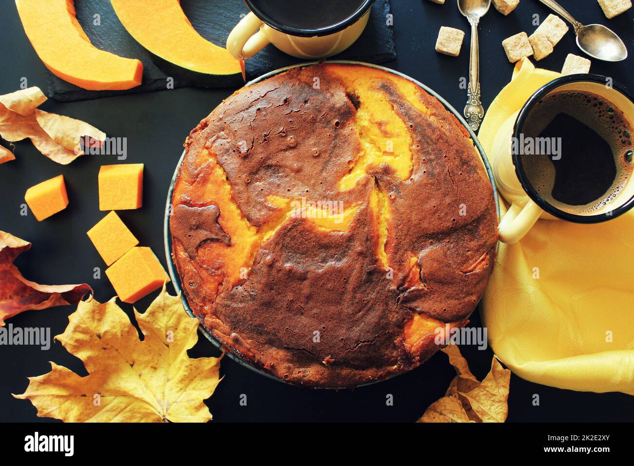 Torta al cioccolato di zucca su sfondo scuro con foglie autunnali, vista dall'alto Foto Stock