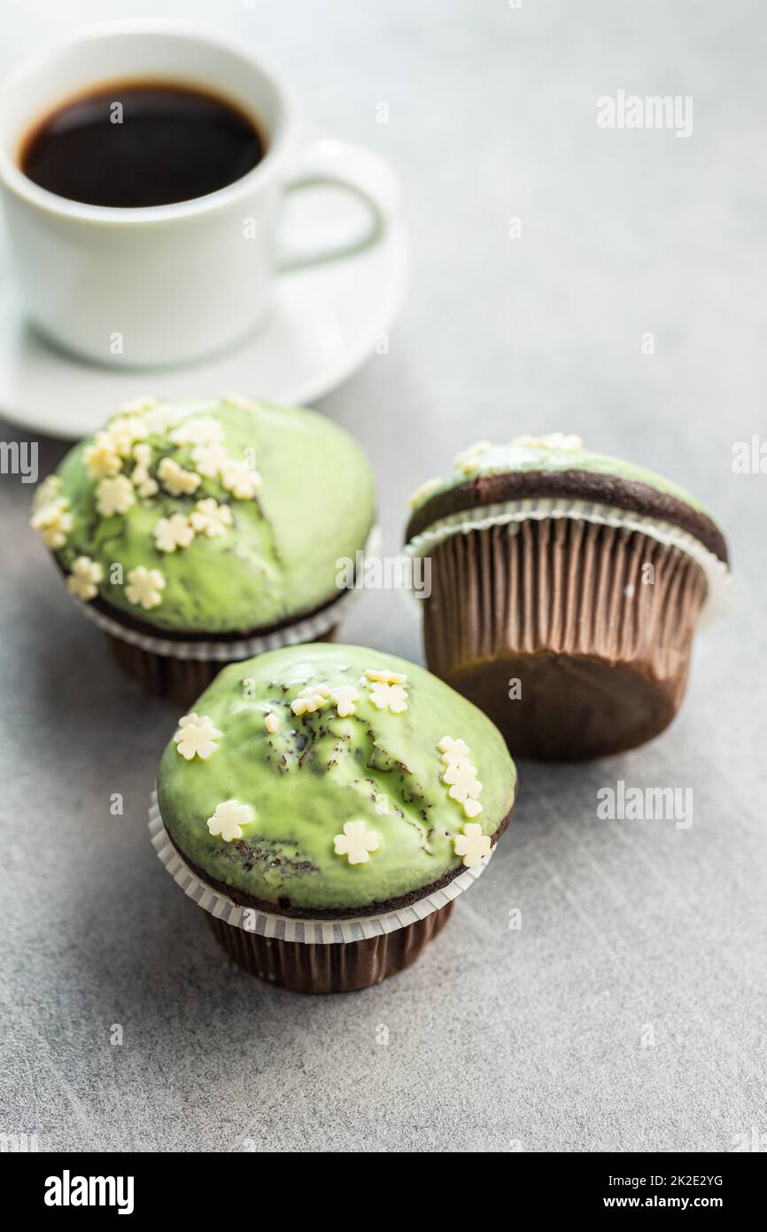 Muffin dolci con glassa al pistacchio. Dessert dolce sul tavolo da cucina. Foto Stock