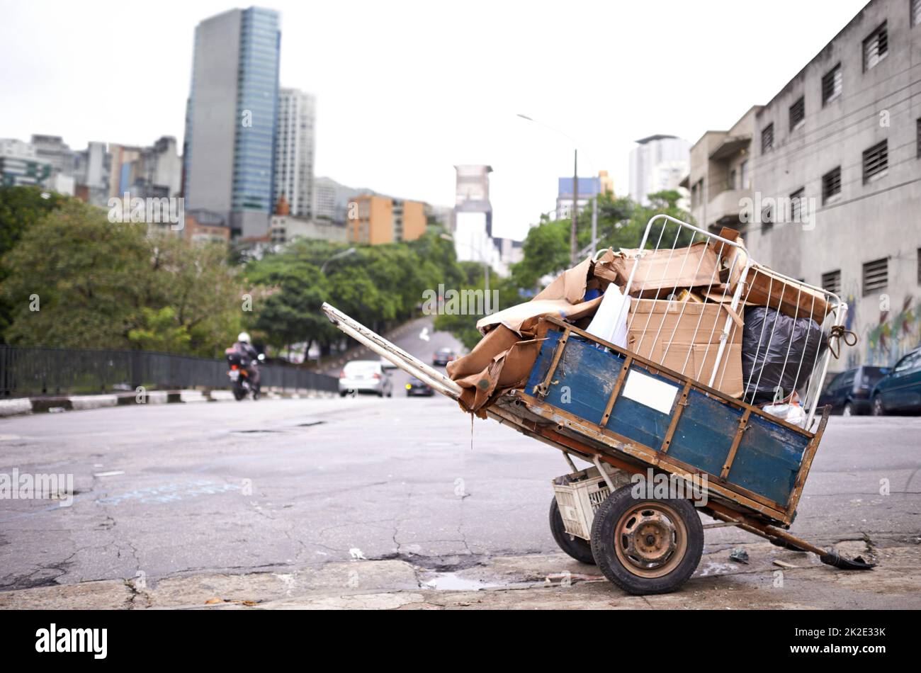 Trasporto dei rifiuti. Sparato di un carro pieno di spazzatura nella strada di una città colpita dalla povertà. Foto Stock