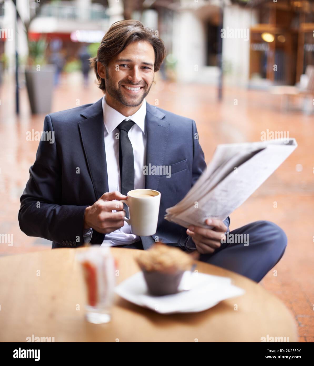 Un po' di tempo per me nel bel mezzo di una giornata piena di impegni. Un uomo d'affari che ha una pausa caffè mentre legge le notizie. Foto Stock