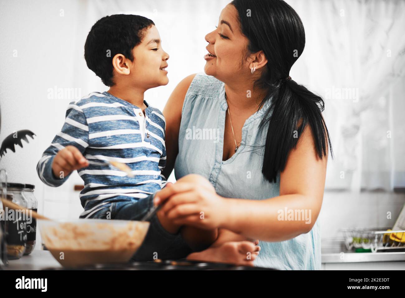 Grazie per essere mummys piccolo aiutante. Shot di una madre e suo figlio piccolo che cuoce insieme a casa. Foto Stock