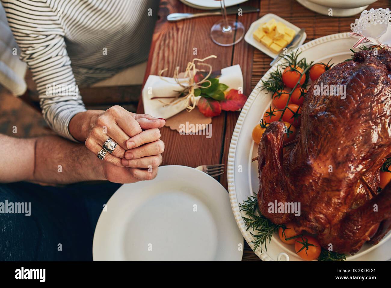 Trova i motivi per dare Grazie. Scatto ad angolo alto di una coppia che tiene le mani al tavolo da pranzo. Foto Stock