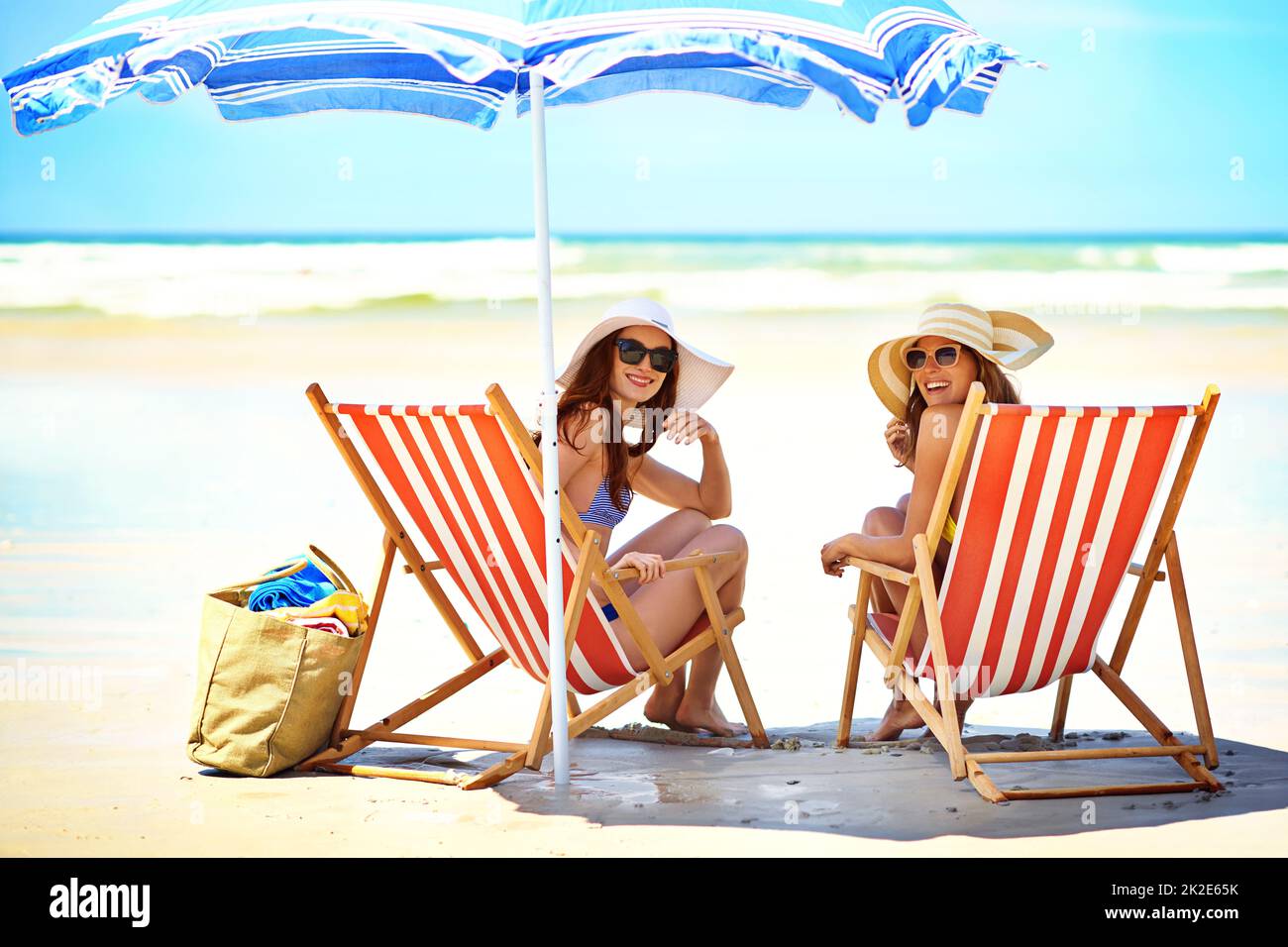 Amiamo l'estate. Ritratto di due belle giovani donne che mangiano un gelato in spiaggia. Foto Stock