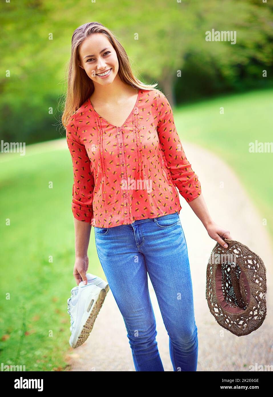 È un'ottima giornata all'aperto. Scatto di una giovane donna che cammina in un parco con le sue scarpe e un cappello. Foto Stock