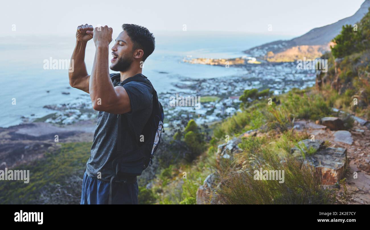 Questa potrebbe essere stata la mia escursione più dura ancora. Scatto di un giovane che celebra il completamento della sua escursione in cima alla montagna. Foto Stock