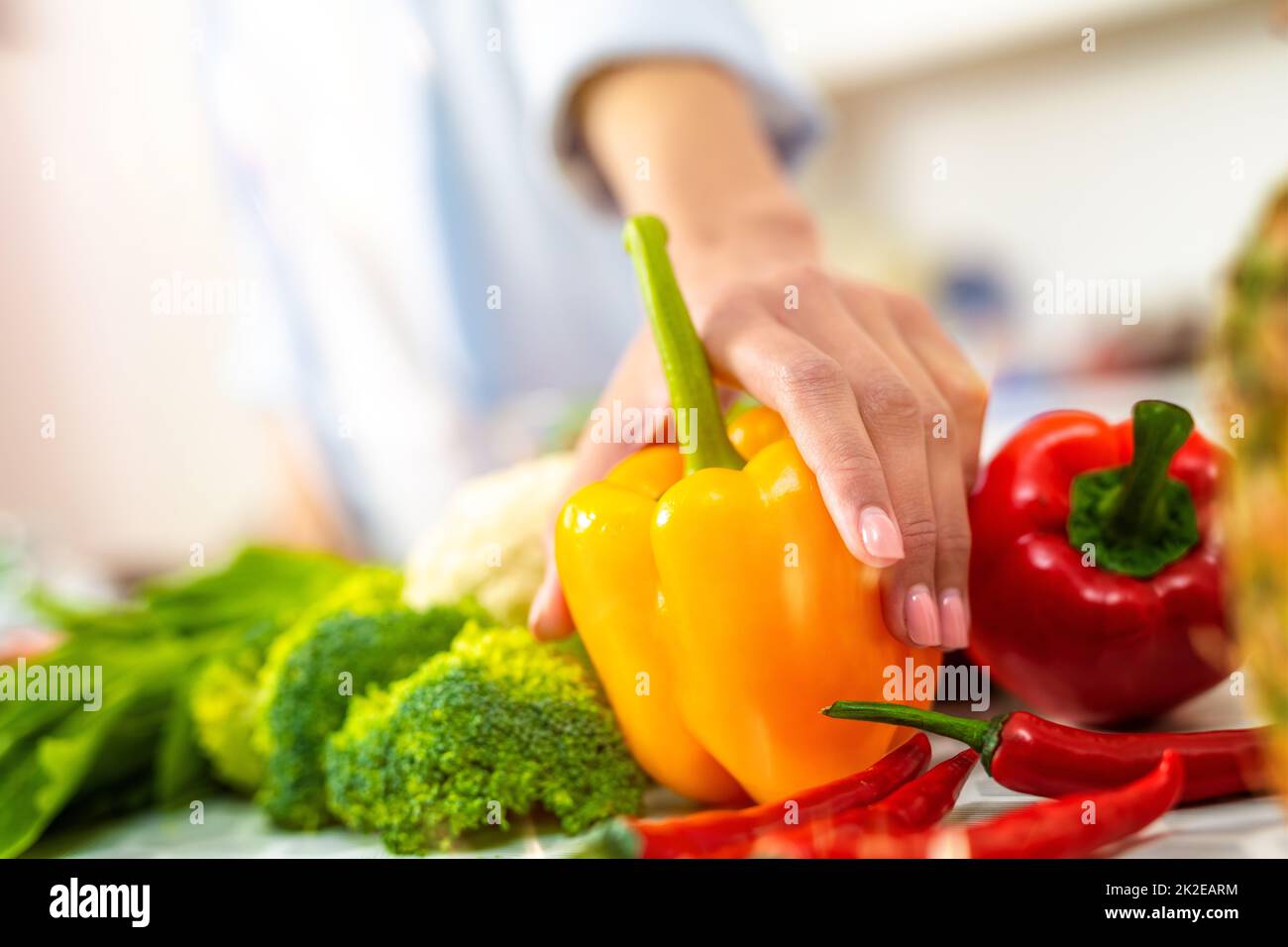 Donna in cucina a casa prepara un piatto genuino con verdure fresche Foto Stock