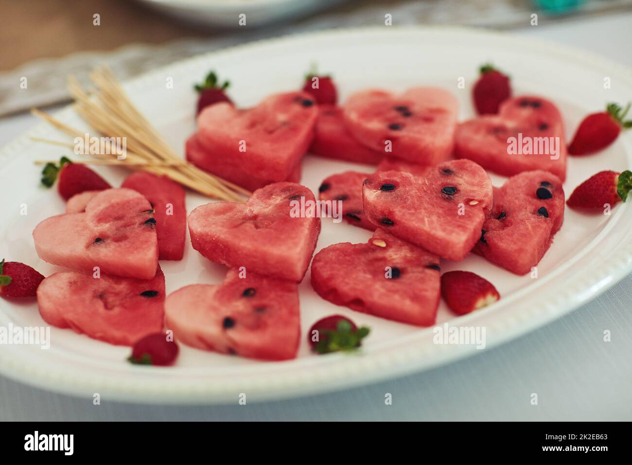 Che grande snack sano. Shot di cocomero tagliato a forma di cuore su un tavolo a una festa di tè all'interno. Foto Stock