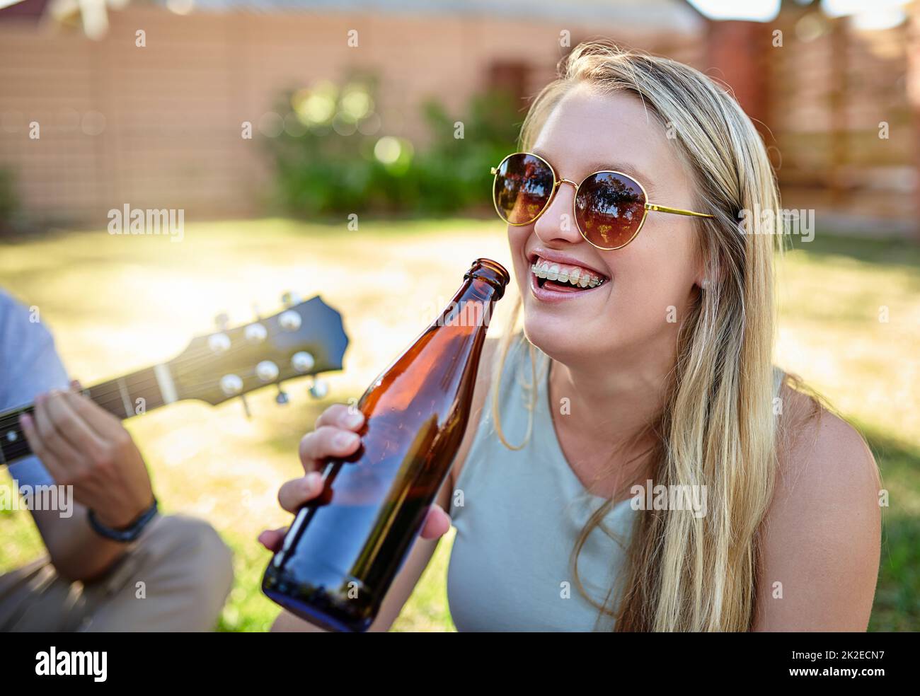 Questa è la vita. Scatto corto di una giovane donna attraente godendo un paio di bevande con gli amici all'aperto nel sole estivo. Foto Stock