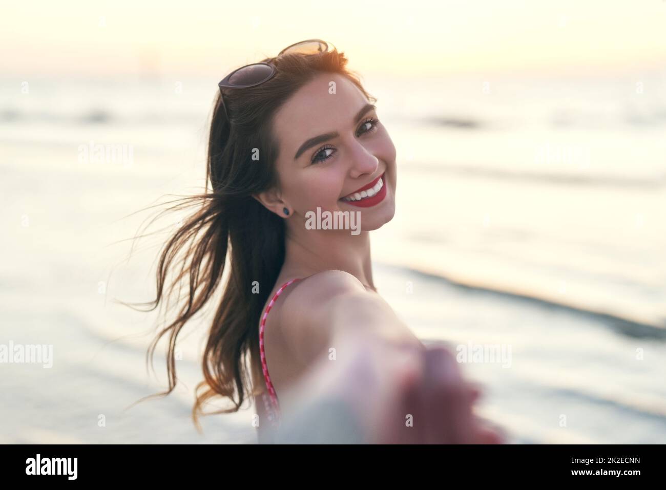 Andiamo avanti in mare ed essere liberi. POV scatto di una bella giovane donna che tiene la sua mano migliori amici alla spiaggia. Foto Stock