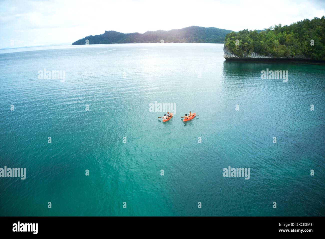 Sono stati in canoa nel sconosciuto insieme. Scatto ad angolo alto di due avventurose coppie giovani in canoa insieme negli splendidi oceani dell'Indonesia. Foto Stock