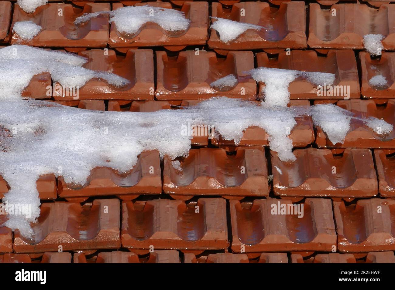 neve che si scioglie sulle tegole del tetto, primavera e neve che si scioglie Foto Stock