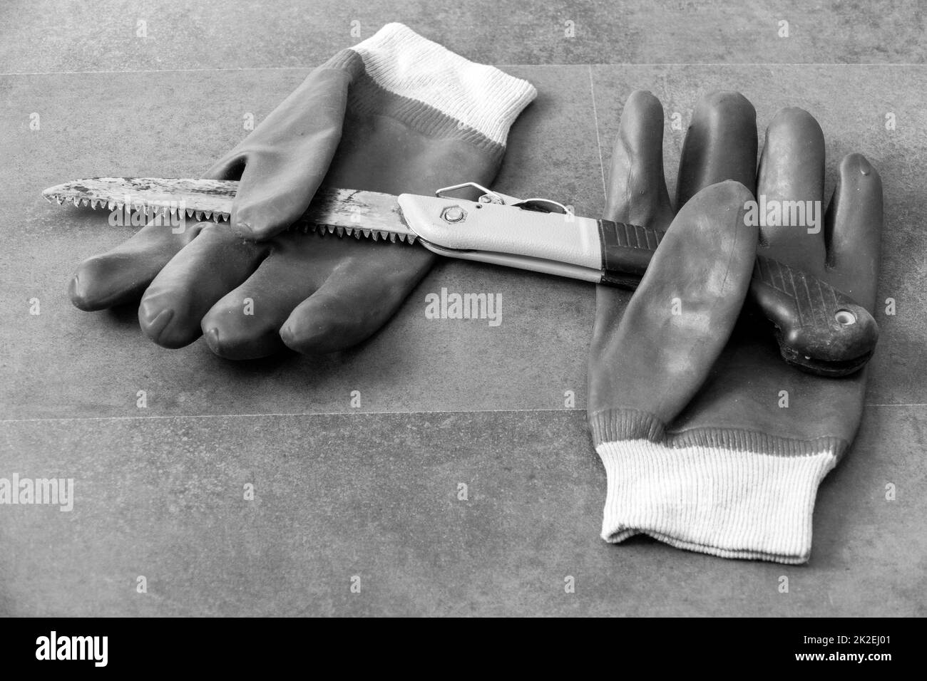 utilizzo di guanti per evitare lesioni alle mani durante il lavoro in officina-sega e guanti da lavoro spessi- Foto Stock