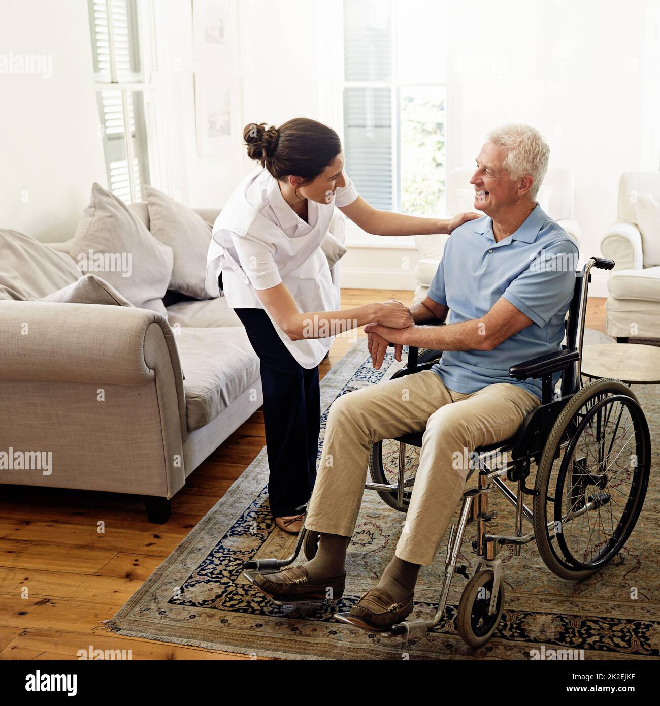 Prendersi cura degli anziani è la sua chiamata. Shot di un operatore sanitario che aiuta un uomo anziano in una sedia a rotelle a casa. Foto Stock