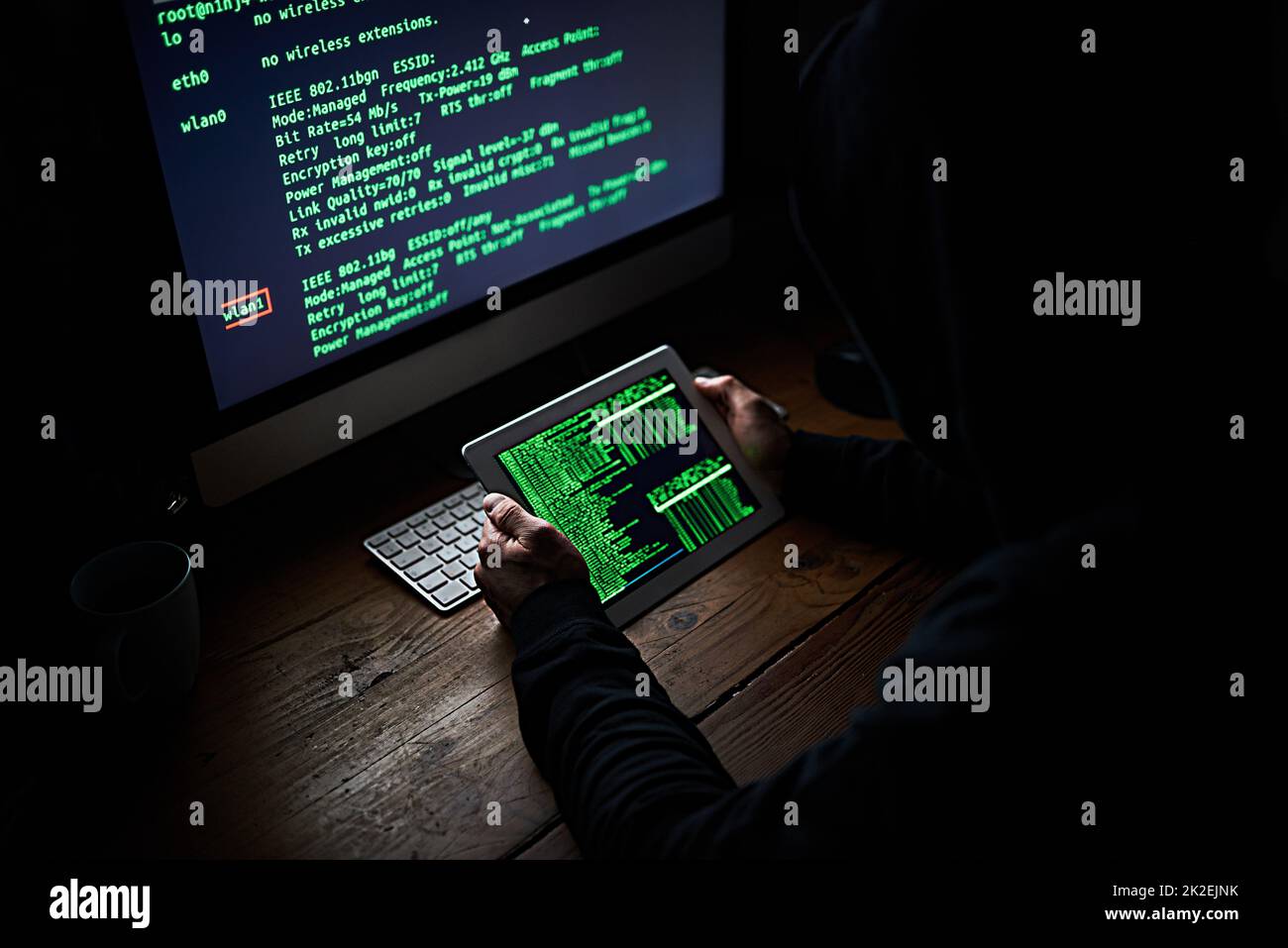 Codificare attraverso la notte. Scatto ad angolo elevato di un hacker non identificabile che utilizza un computer a tarda notte. Foto Stock