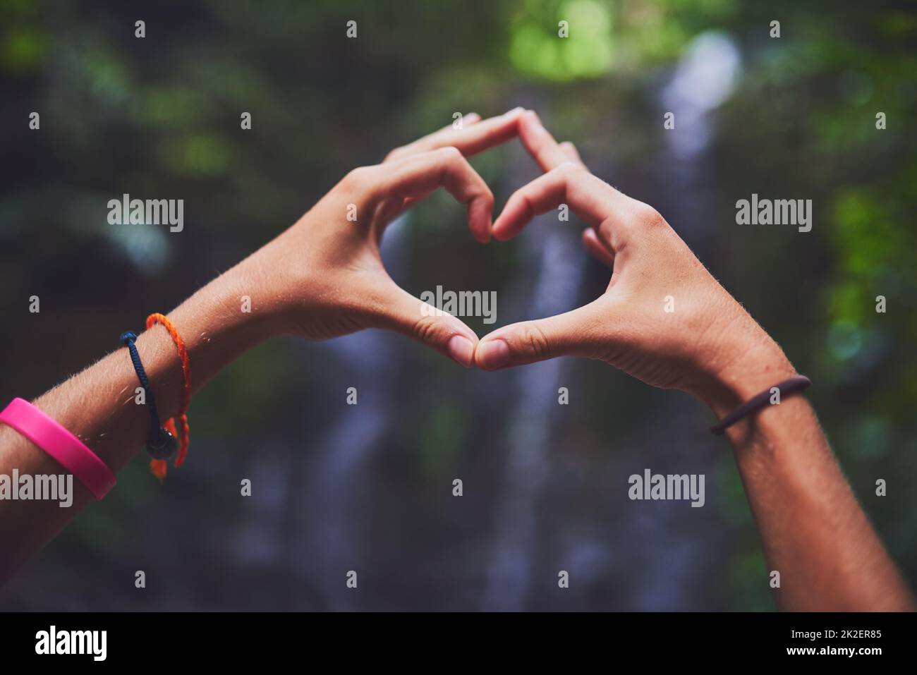 Il viaggio è il suo vero amore. Scatto di una giovane donna inidentificabile che fa un gesto di cuore con le mani nella giungla. Foto Stock