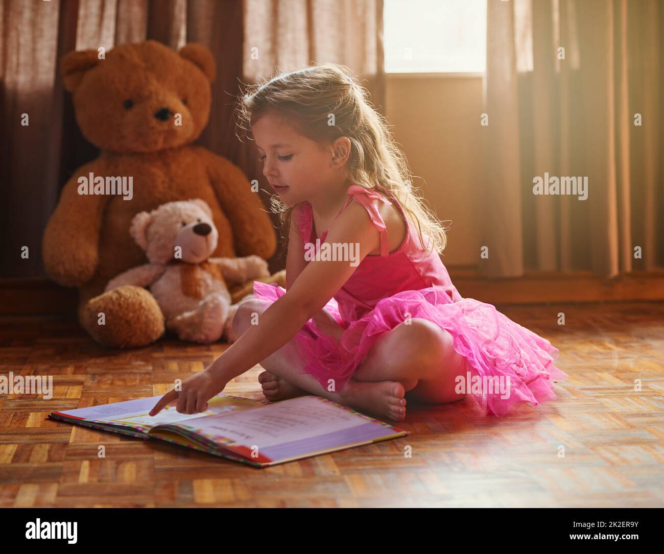 Imparare a leggere significa imparare a vedere. Scatto di una ragazza piccola che legge un libro di storia. Foto Stock