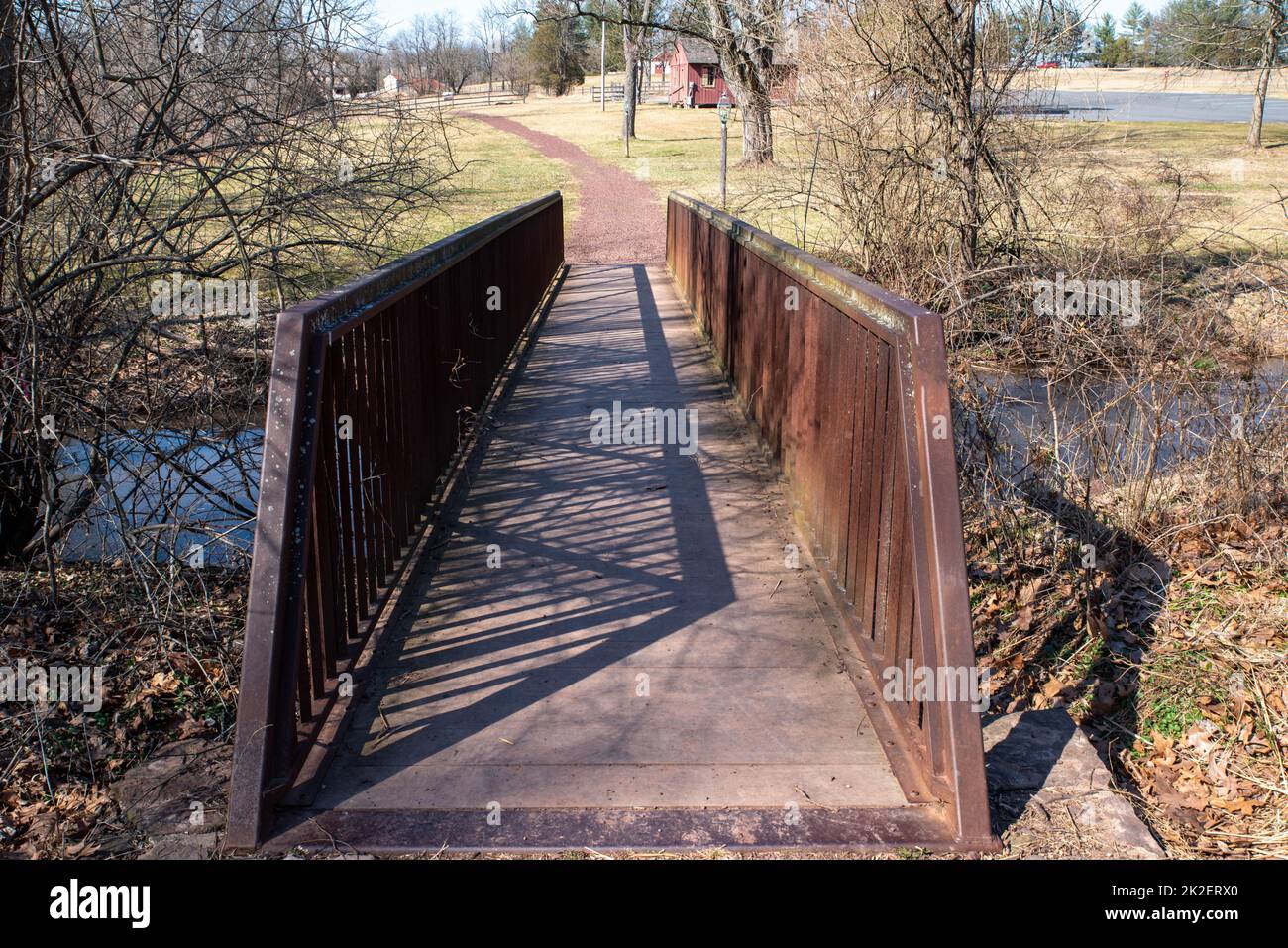 Un ponte attraversa un ruscello per un sentiero escursionistico attraverso la campagna Foto Stock