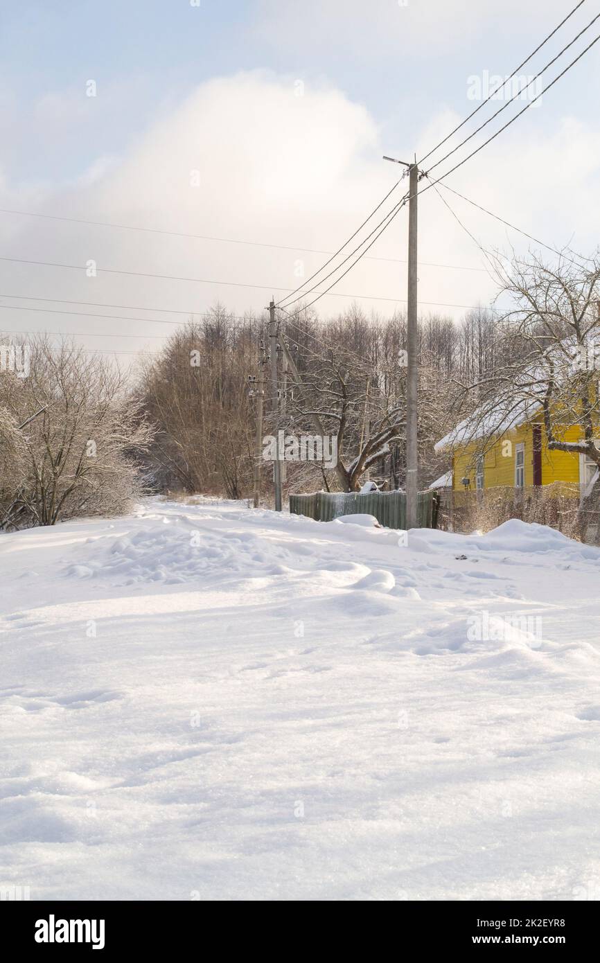 Strade di paese coperte di neve in inverno. Mattina gelida. Immagine verticale Foto Stock