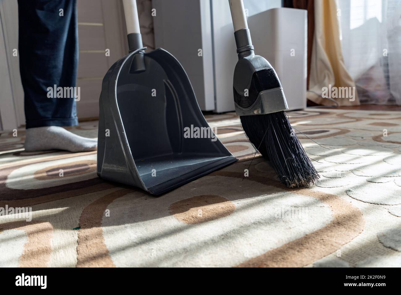 Cleaning.Clean su la spazzatura dal pavimento con una scopa per la pulizia.Sweep via la polvere e lo sporco con una spazzola in un polverpan.Swing il tappeto con una scopa a casa.Indoor strumenti di pulizia. Foto Stock