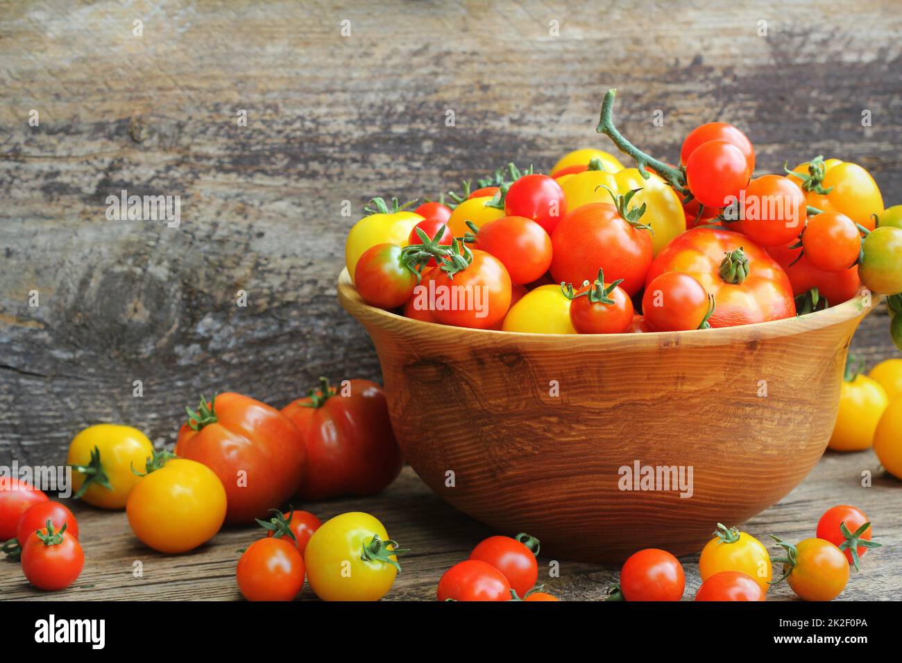Ciotola di legno con vite freschi stagionati cimelio di pomodori dal mercato degli agricoltori Foto Stock