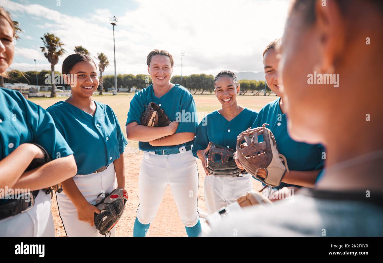 Squadra di donne giocatori di baseball, data strategia e motivazione da allenatore per vincere la partita. Vincere nello sport significa leadership, lavoro di squadra e orgoglio Foto Stock