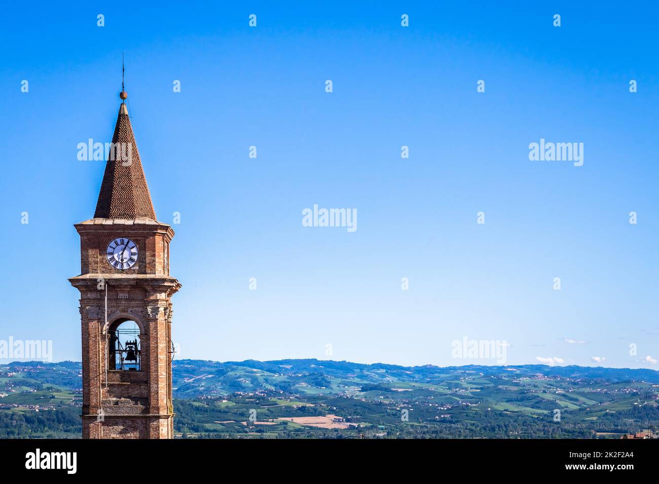 Colline piemontesi in Italia con campagna panoramica, campo vigna e cielo blu. Il campanile di Govone sulla sinistra. Foto Stock