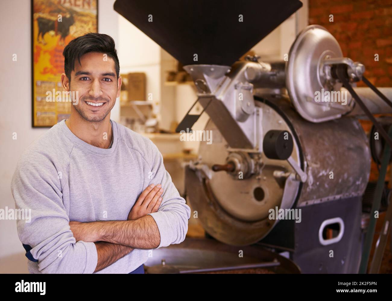 È qui che inizia quella tazza di caffè. Una macchina che macina e torrefa i chicchi di caffè. Foto Stock