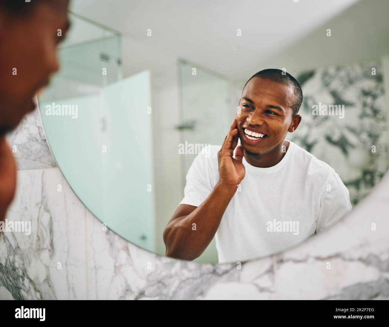 Ehi, bello. Scatto di un giovane uomo che passa attraverso la sua routine mattutina in bagno a casa. Foto Stock
