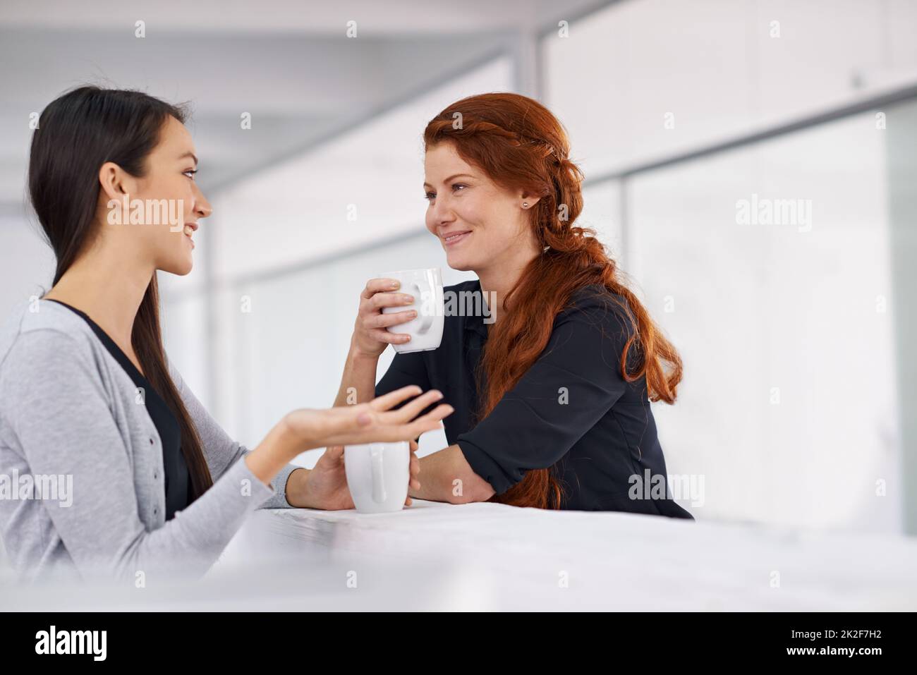Amano le pause caffè. Due colleghi femmine chiacchierano con il caffè durante la pausa. Foto Stock