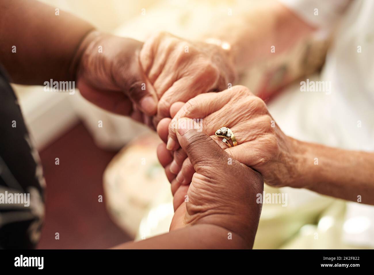 Gentilezza Paga in avanti. Scatto corto di una donna anziana che tiene le mani dei suoi amici in comodità. Foto Stock