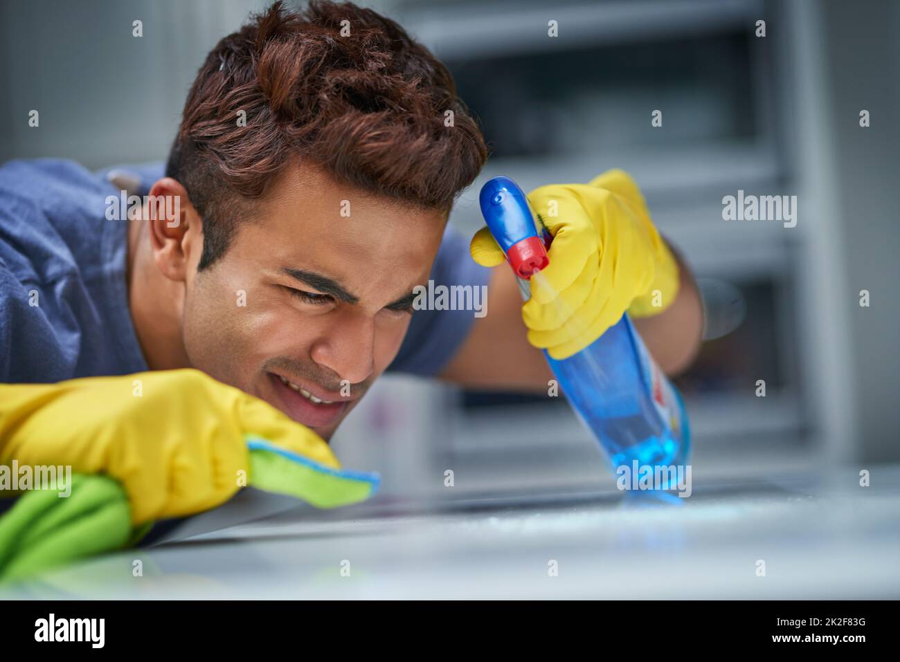 Lo pulirò stridulo. Colpo di un giovane che fa le faccende domestiche. Foto Stock