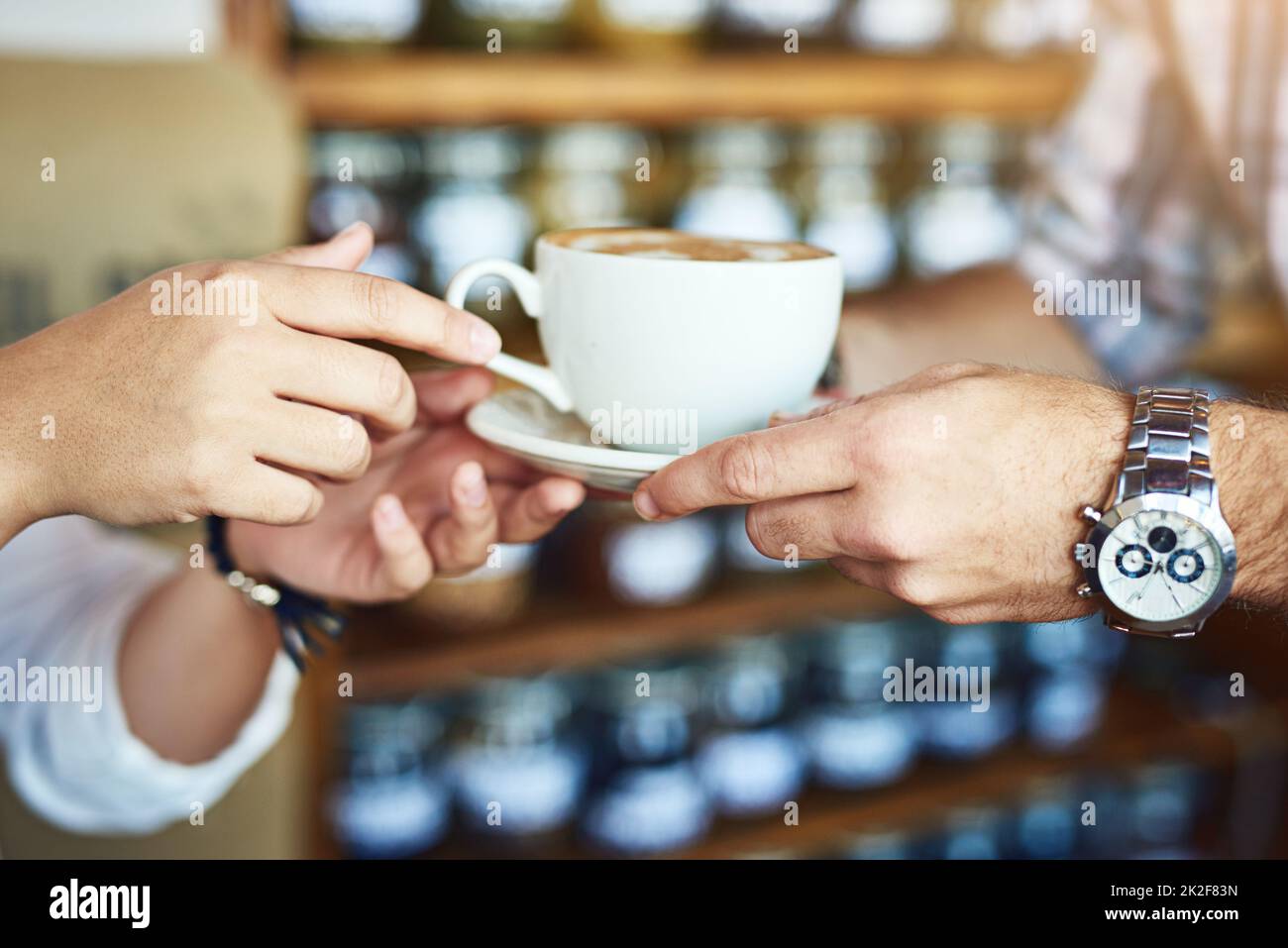 Dare un caffè è dare l'amore. Shot di una donna irriconoscibile che riceve una tazza di caffè da un cameriere irriconoscibile in un bar. Foto Stock