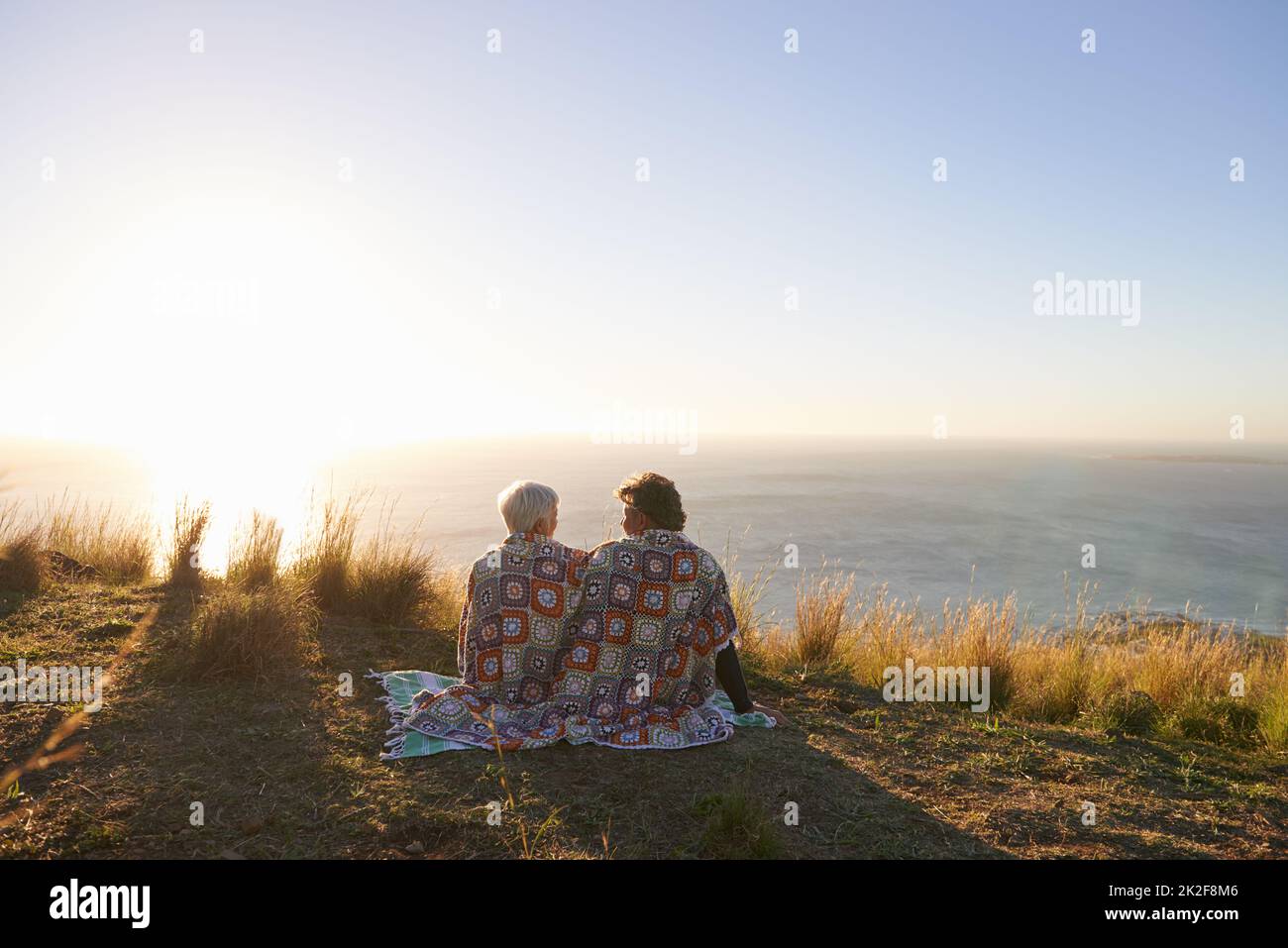 Condividere un momento dolce. Vista di una coppia anziana seduta su una collina insieme. Foto Stock