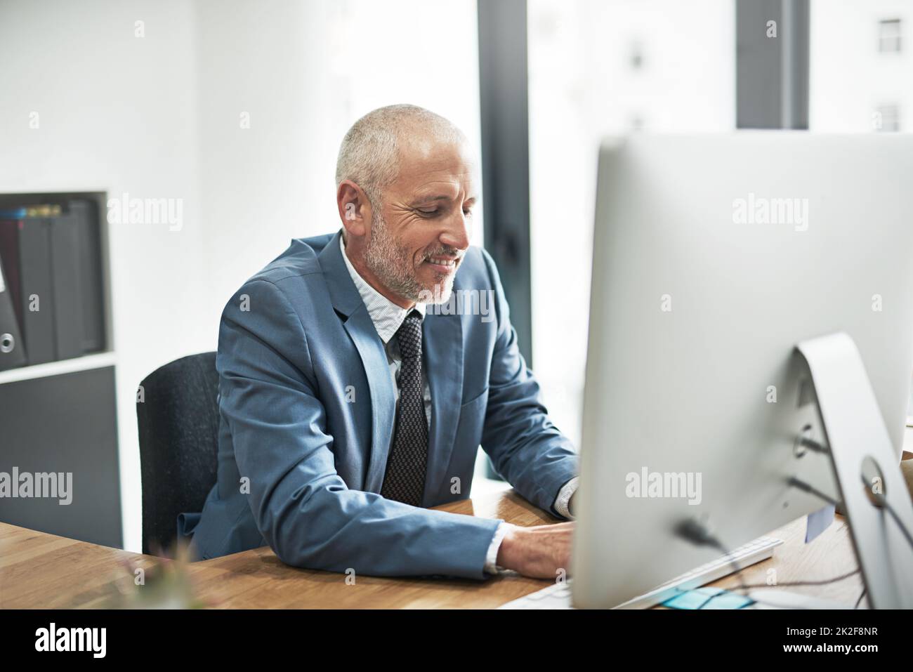 Business guidato dall'era digitale. Scatto corto di un uomo d'affari maturo che lavora su un calcolatore in un ufficio moderno. Foto Stock