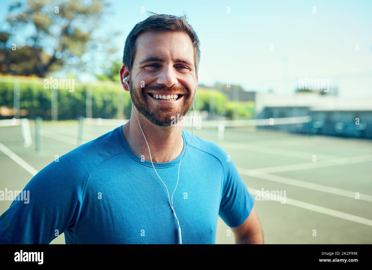 In qualità di atleta, la forma fisica viene sempre prima di tutto. Ritratto di un giovane sportivo che ascolta musica mentre si esercita su un campo da tennis. Foto Stock