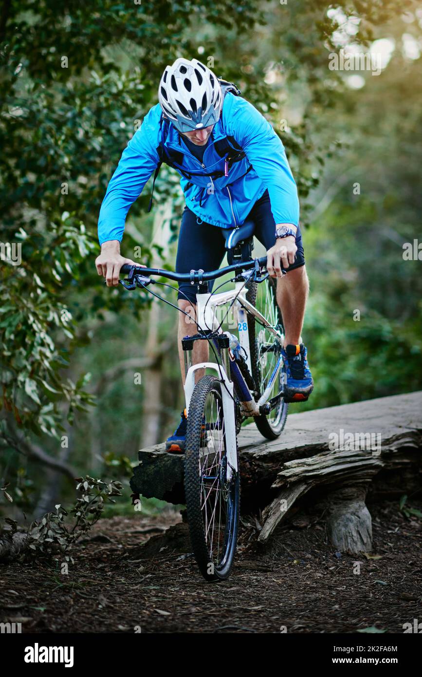 Navigare il sentiero con grande abilità. Sparato di un ciclista maschile che corre lungo un sentiero per mountain bike. Foto Stock