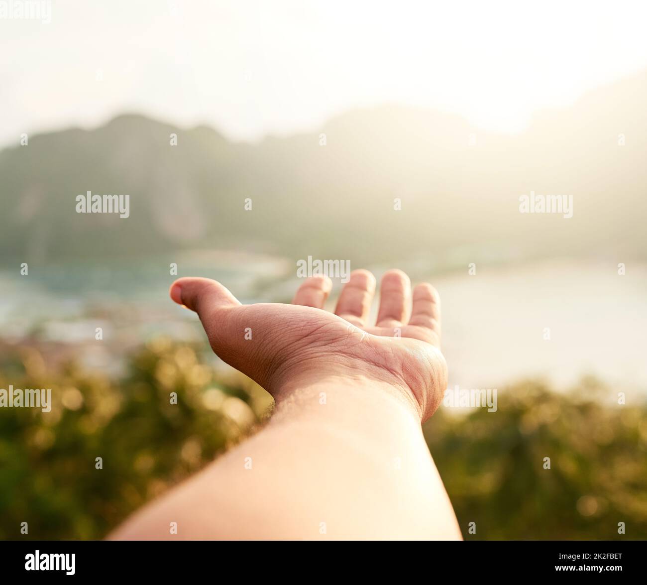 Raggiunga per i suoi sogni di vacanza. Scatto ritagliato di una persona non identificabile che tiene fuori la loro mano mentre ammirando una vista costiera. Foto Stock