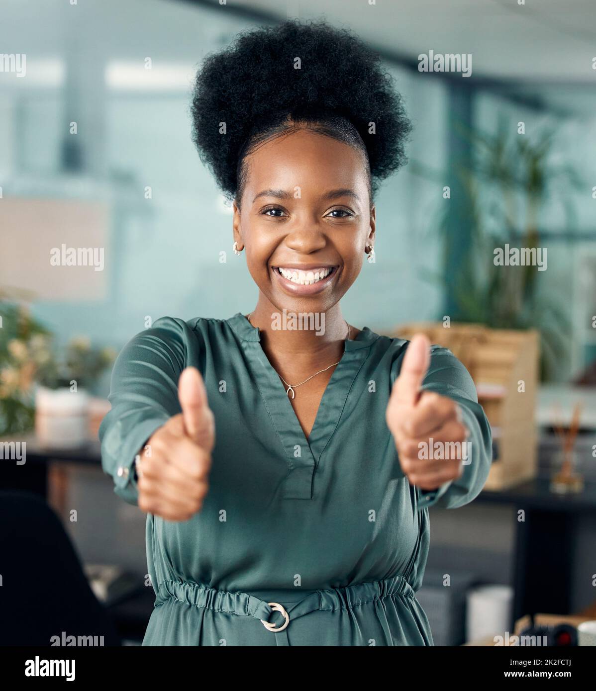 Restate dedicati e il successo sarà vostro. Ritratto di una giovane donna d'affari che mostra i pollici in un ufficio. Foto Stock