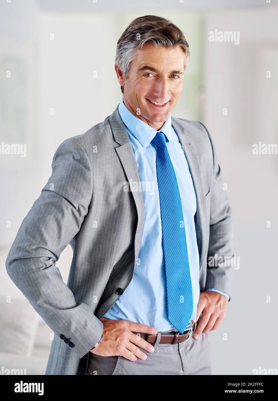 Il suo acumen di affari non conosce eguali. Ritratto di un uomo d'affari maturo sorridente in piedi con le mani sui fianchi. Foto Stock