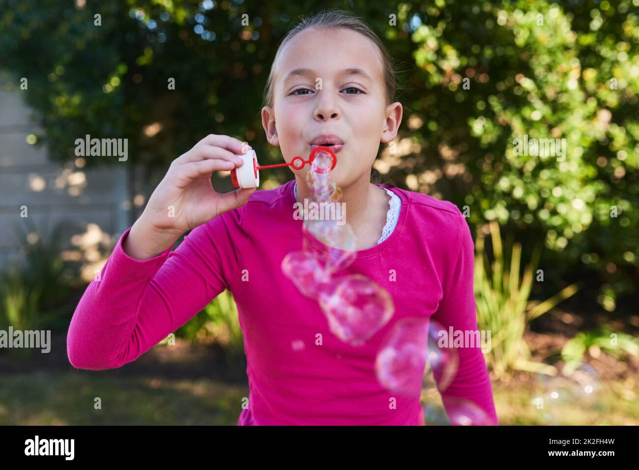 Che cosa sarebbe il mondo senza bolle. Ritratto di una ragazza carina soffiando bolle fuori. Foto Stock