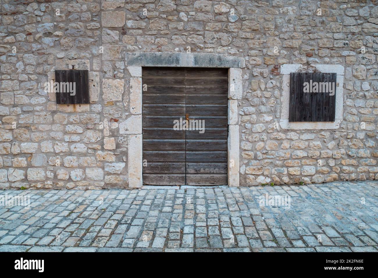 Muro di pietra con porte e finestre. Foto Stock