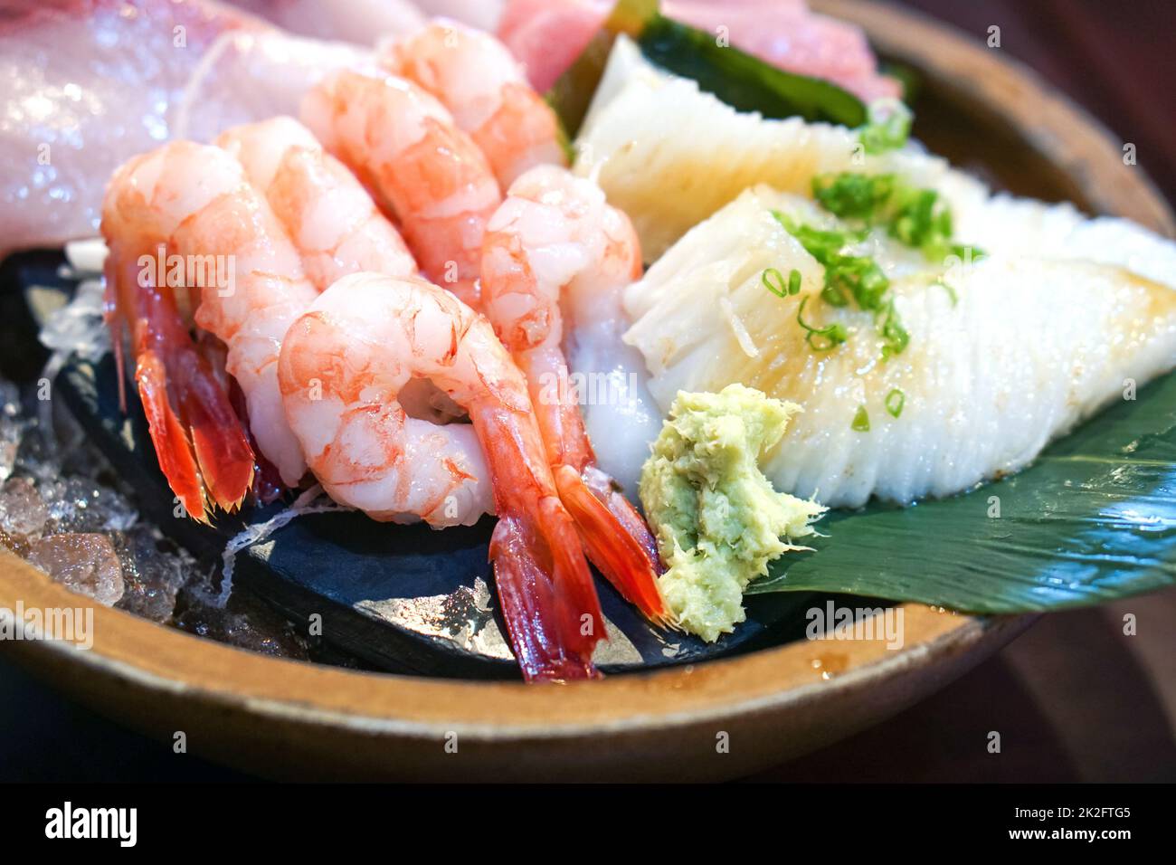 Il set sashimi è ben organizzato in un piatto di legno. Buffet di cucina Giapponese. Scelta dello chef: Gamberi, engawa, tonno e hamachi Foto Stock