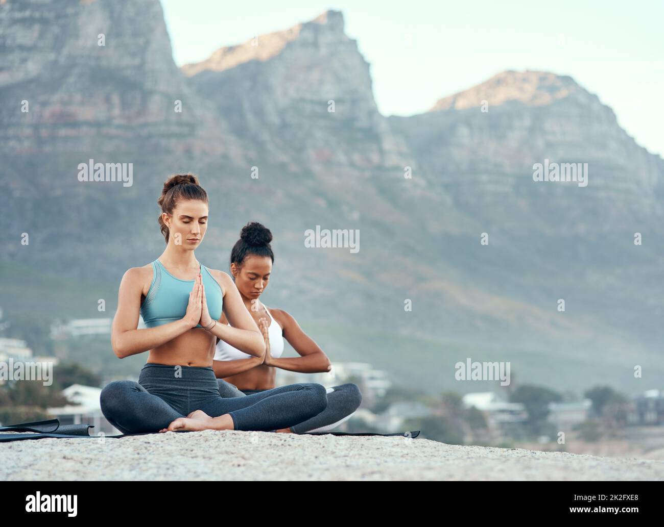 Lo yoga vi porta in un viaggio meraviglioso. Shot di due giovani donne sportive che praticano lo yoga all'aperto. Foto Stock