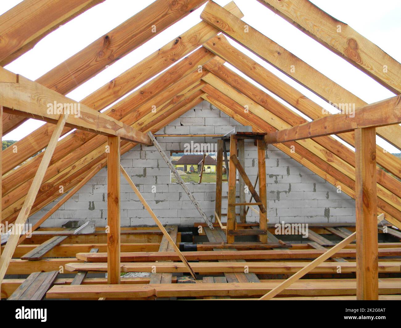 Mansarda non rifinita costruzione tetti, travi in legno, grondaie, legname. Casa tetto struttura in legno. Foto Stock