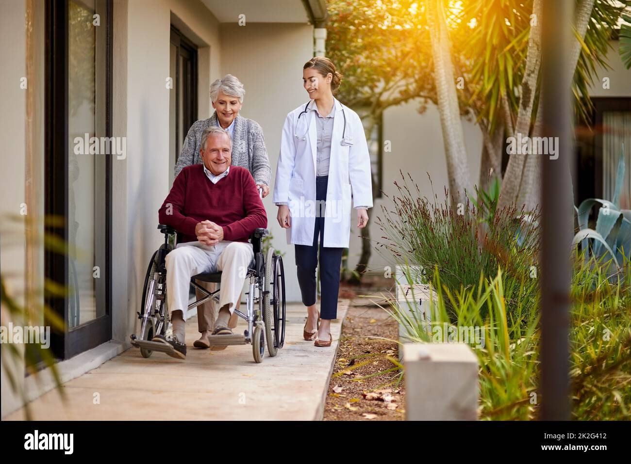 HES desideroso di Vai a casa. Shot di una coppia anziana e di un'infermiera fuori da una casa di cura. Foto Stock