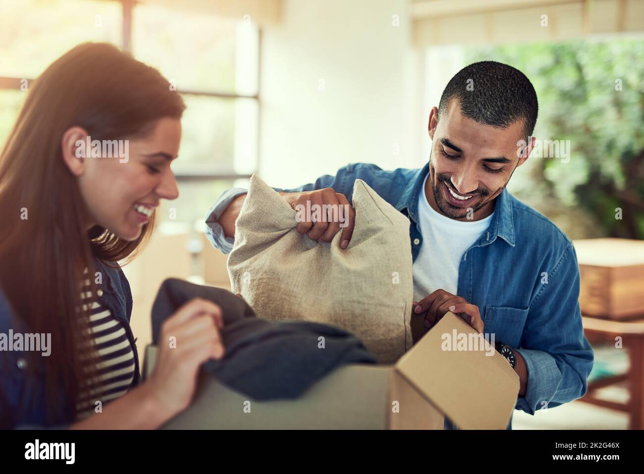 Theyre eccitato per cominciare depositarsi nel loro nuovo nido. Scatto corto di una giovane coppia che disimballo scatole mentre si sposta nella loro nuova sede. Foto Stock