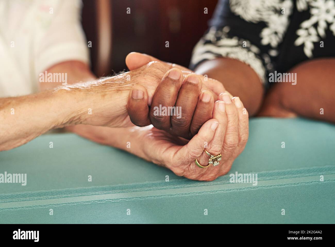 Le mani utili sono mani piene di speranza. Scatto corto di una donna anziana che tiene le mani dei suoi amici in comodità. Foto Stock