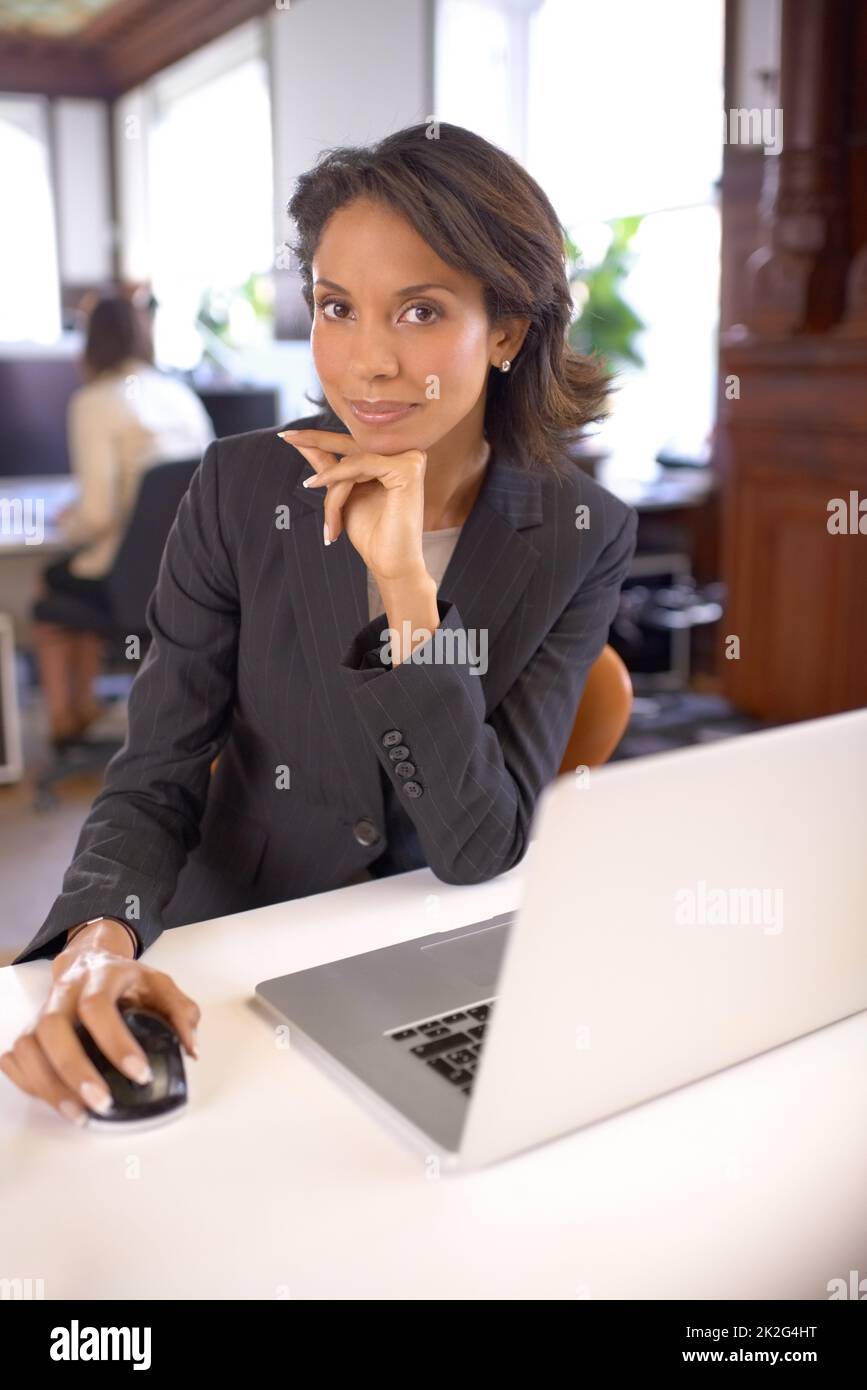 Consuma il consumatore professionale. Ritratto di una donna d'affari attraente seduta alla sua scrivania. Foto Stock