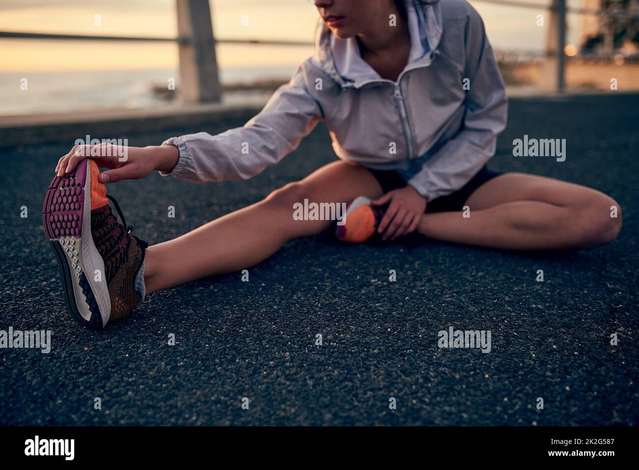 USA il tuo tempo libero saggiamente. Scatto di una giovane donna sportiva che si allunga prima della sua corsa. Foto Stock