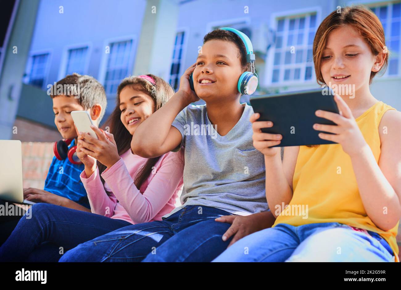 Il futuro è nostro da creare. Girato di un gruppo diversificato di bambini che si divertono con la tecnologia all'aperto. Foto Stock